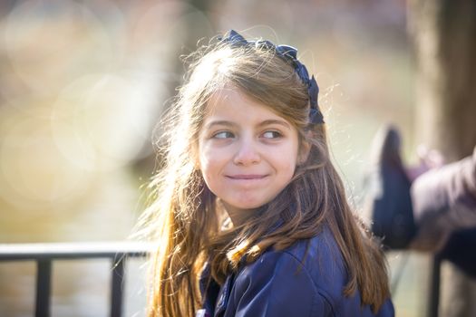 Girl looking in her back, bokeh at background.