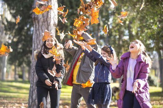 Friends playing with autumn leaves