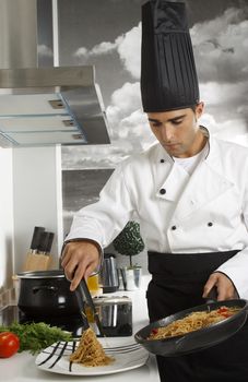 Chef serving rice noodles in plate.