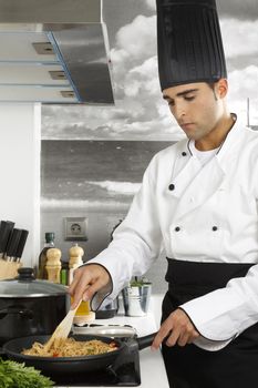 Chef stirring rice noodles.