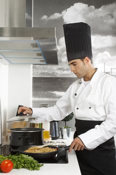 Chef checking boiling water in pot.