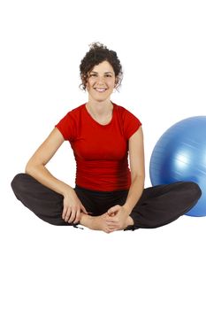 Young woman sitting with a blue yoga ball behind her.