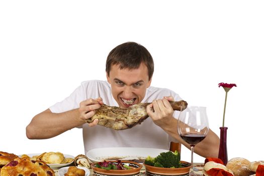 Young man biting eagerly a leg of lamb. Isolated of white background.