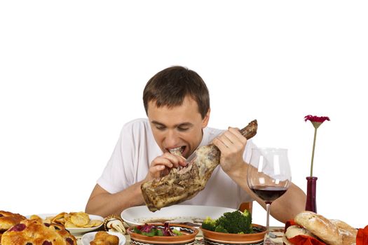 Young man biting a leg of lamb. Isolated of white background.