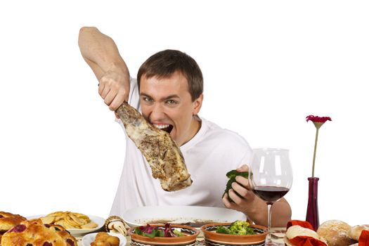 Bad mannered young man eating a leg of lamb. Isolated of white background.