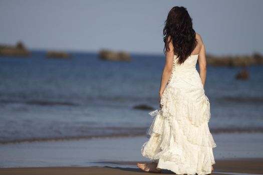 Bride walking in the beach.