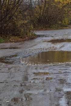 roadway in a provincial Russian city in poor condition, pits and dirt, vertical frame