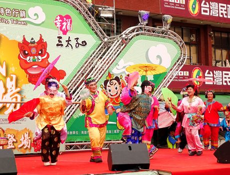 KAOHSIUNG, TAIWAN -- AUGUST 15, 2015: Elderly performers in traditional rural costumes dance on the stage during the Third Prince temple carnival.