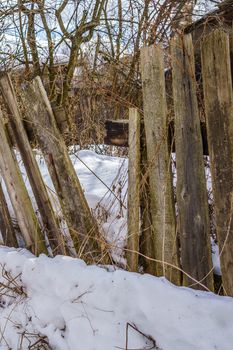 old fence around the garden of nailing boards, winter day