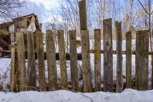 old fence around the garden of nailing boards, winter day