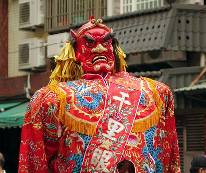 KAOHSIUNG, TAIWAN -- APRIL 20, 2014: A large demon statue with terrifying expression is carried during a local religious procession