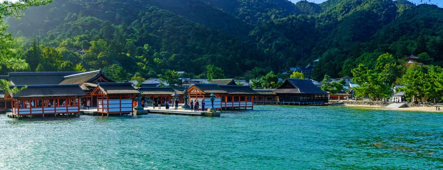 Miyajima, Japan - October 13, 2019: Panoramic view of the Itsukushima Shrine, at high tide, with visitors, in Miyajima (Itsukushima) Island, Japan