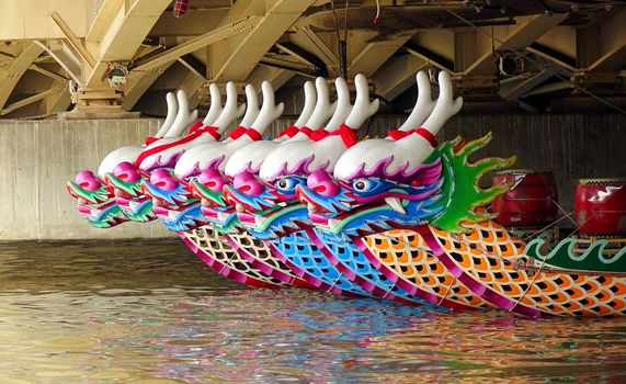 KAOHSIUNG, TAIWAN -- MAY 21, 2017: Traditional dragon boats are anchored under a bridge on the Love River in preparation for the upcoming Dragon Boat Festival.