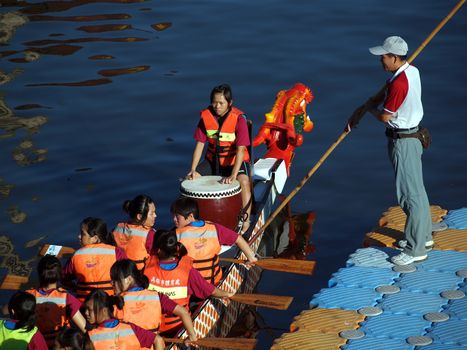 KAOHSIUNG, TAIWAN - JUNE 6: A team of female rowers waits at the starting line for the dragon boat race on the Love River on June 6, 2011 in Kaohsiung
