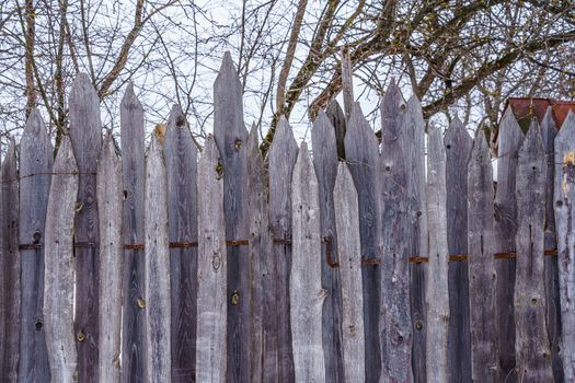 wooden fence of boards nailed to the crossbar on a winter day