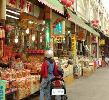 KAOHSIUNG, TAIWAN -- MAY 31, 2014: Shoppers buy goods at the famous Zongjie dry goods market which sells grains, nuts, dried meat, fish, seafood, herbs and fruits.