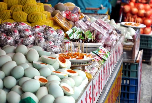 PINGTUNG, TAIWAN -- JULY 6 , 2017: A market stall sells local specialties such as salted duck eggs and preserved eggs and offers samples for tasting.