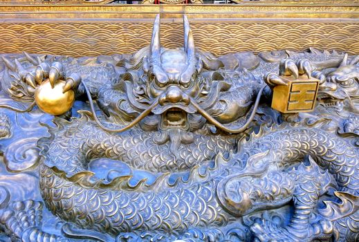 KAOHSIUNG, TAIWAN -- JUNE 10 , 2017: A large bronze sculpture of a dragon marks the entrance to the Earth God Temple in Fengshan District.