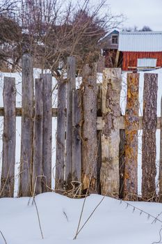 wooden fence of boards nailed to the crossbar on a winter day