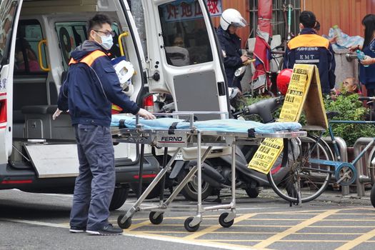 KAOHSIUNG, TAIWAN -- DECEMBER 31, 2017: A medical emergency team prepares to load an old man who is feeling unwell into an anbulance.
