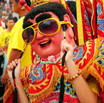 KAOHSIUNG, TAIWAN -- AUGUST 15, 2015: A dancer in a modernized costume of the Chinese Third Prince tradition performs techno dance moves at a local temple carnival.