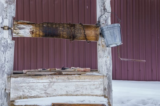 wooden well with a tin bucket, winter day