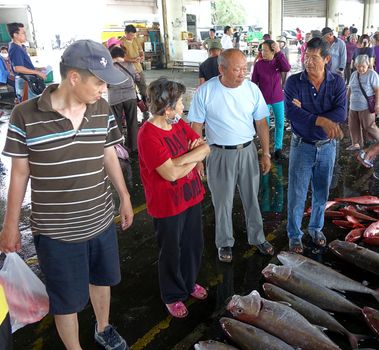 KAOHSIUNG, TAIWAN -- MAY 3, 2014: Prospective buyers bargain over fresh fish at Sinda Fishing Port.