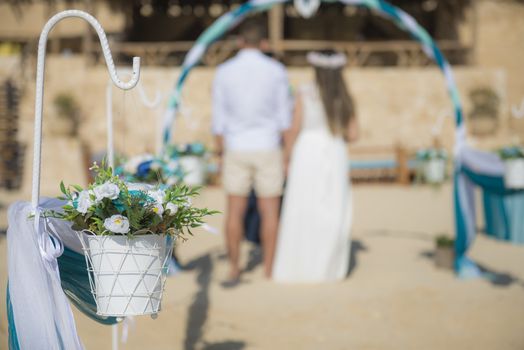 Setup of wedding day marriage couple ceremony aisle with drapes and arch on sandy tropical beach paradise