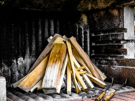 Firewood in a concrete grill piled up and ready to start