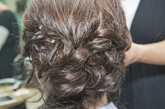 Closeup detail of female womens hair styling being styled at hairdresser salon