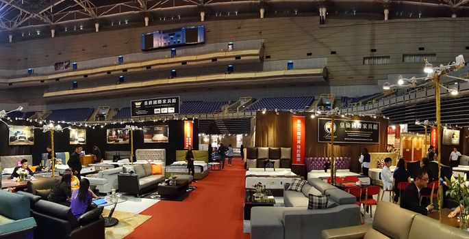 KAOHSIUNG, TAIWAN -- APRIL 5, 2019: People look at living room sets and beds at a furniture promotion event.