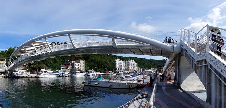 KAOHSIUNG, TAIWAN -- JULY 10, 2014: Panoramic view of a new pedestrian bridge crossing the Gushan marina near to the port of Kaohsiung city.