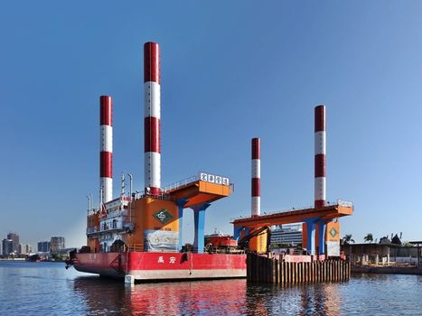 KAOHSIUNG, TAIWAN -- FEBRUARY 7, 2019: A floating dock construction rig is at work in Kaohsiung Harbor at a bridge building project.