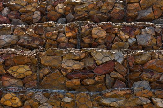 Close-up of a rock and mesh wire containment wall to stop hillside erosion, Mossel Bay, South Africa