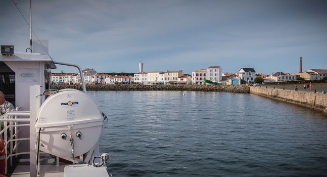 Ile d Yeu, France - September 16, 2018: View of the bridge of a ferry that enters the harbor of the island of Yeu where travelers are sitting to admire the show on a summer day