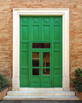 Green door of old building in Rimini, Italy