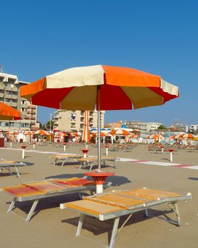 Orange umbrellas and sunbeds on the beach of Rimini in Italy
