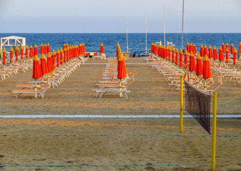 Orange umbrellas and sunbeds on the beach of Rimini in Italy