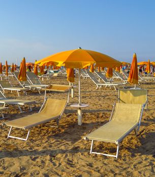 Orange umbrellas and sunbeds on the beach of Rimini in Italy