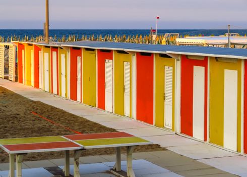 Yellow and red beach cabins in Rimini, Emilia-Romagna, Italy