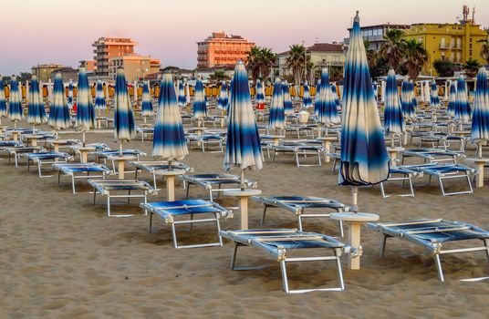 White blue umbrellas and sunbeds on the beach of Rimini in Italy
