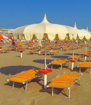 White umbrellas and sunbeds on the beach of Rimini in Italy