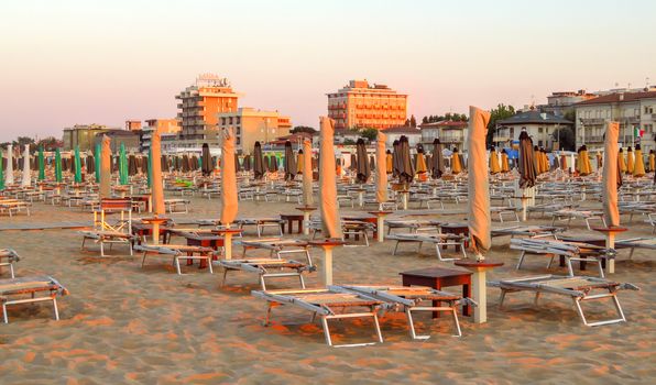 Rimini, Italy - June 14, 2017: Evening Rimini beach with sun beds and umbrellas.