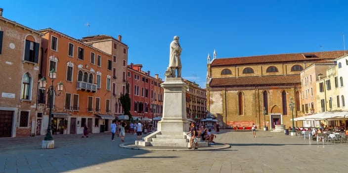 Venice, Italy - June 20, 2017: Campo Santo Stefano square with Nicolo Tommaseo monument and Santo Stefano church. Unrecognizable people are walking down the square.