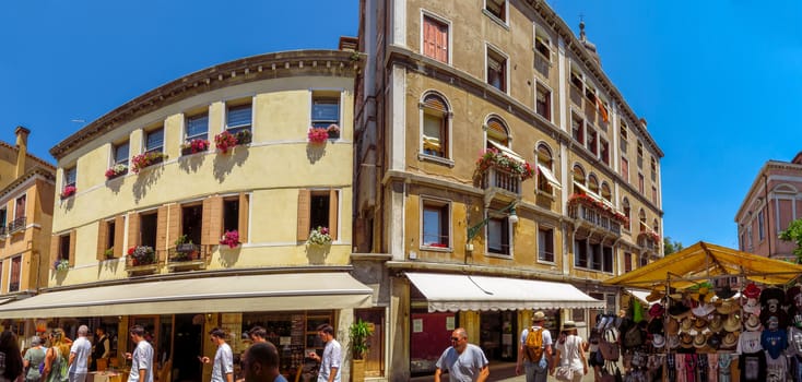 Venice, Italy - June 20, 2017: View to architecture old city in Venice, Italy. Unrecognizable people are walking down the street in the old center.