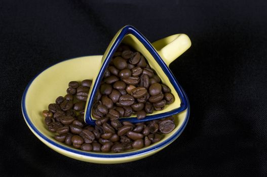 A yellow coffee cup and coffee beans
