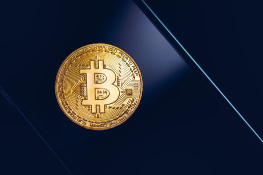 Bitcoin symbol over mobile screen, minimalist approach. Bitcoin on stock market. New digital money. Golden Bitcoin over smartphone display.