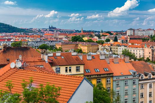 View of Prague Castle over red roof from Vysehrad area at sunset lights, Prague, Czech Republic. Scenic view of Prague city, Prague castle and Petrin tower from Vysehrad overlooking red roofs 
