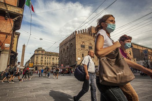 BOLOGNA, ITALY 17 JUNE 2020: Palazzo Re Enzo: a famous historic building in Bologna, Italy with people walking in the square