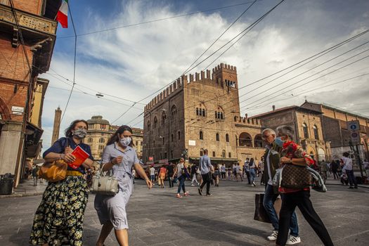 BOLOGNA, ITALY 17 JUNE 2020: Palazzo Re Enzo: a famous historic building in Bologna, Italy with people walking in the square